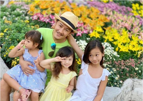 陈浩民晒出与三个女儿合影：他和三个女儿坐在花坛露出灿烂幸福笑容