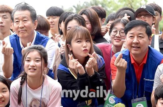 韩国知名女歌手洪真英在首尔参加了公益活动，她在人群中俏皮的用手比心