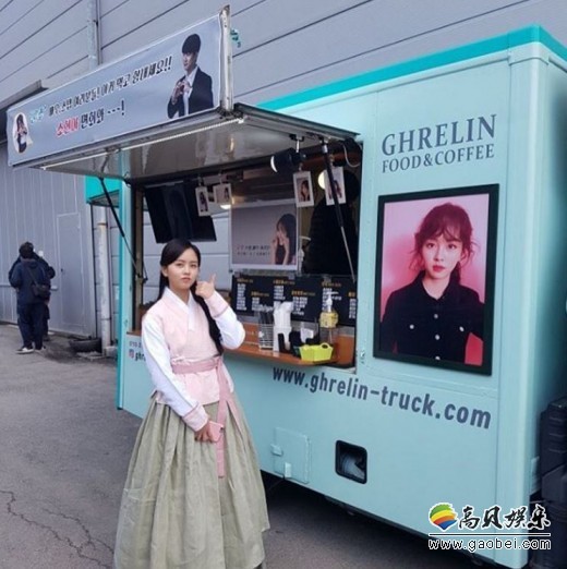 着韩服的金所炫在玉泽演送的咖啡车前伸出大拇指