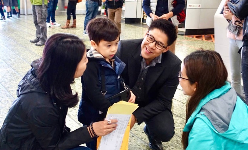 霍启刚一家三口街头卖旗筹款:可谓相当接地气 霍启刚一家三口街头卖旗筹款:可谓相当接地气