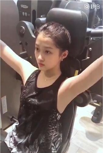 工作室分享关晓彤本人健身小视频：扎着马尾、身穿黑色背心做手臂锻炼