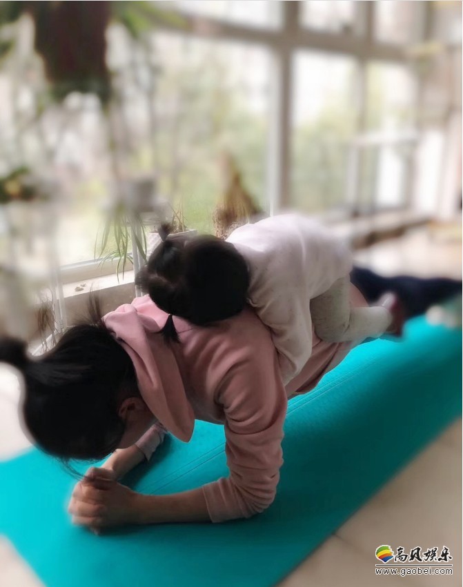陶昕然晒出与女儿互动近照：休闲运动装扎丸子头，身背女儿做平板支撑
