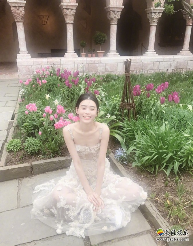 奚梦瑶晒出一组工作照：身穿白色纱裙坐在花丛处，造型非常的小仙女