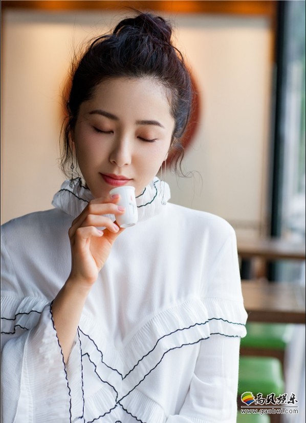 演员曾黎曝光一组最新写真：照片中她身穿白色长衫，手执茶杯品味茗稥