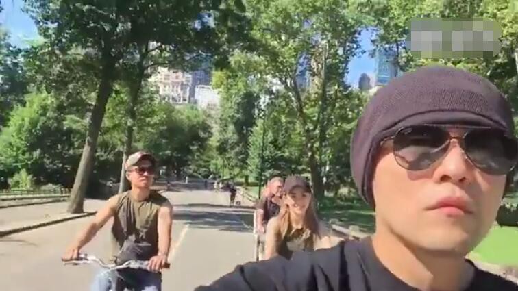 周杰伦单手骑车：一边和昆凌说着话，然后还用另外一只手拿着手机拍摄