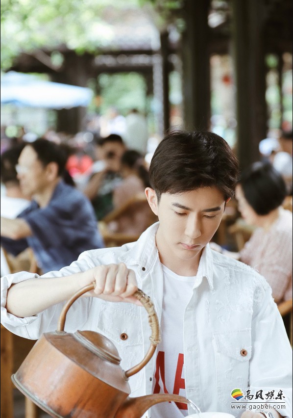 于朦胧夏日写真照：他坐在竹椅上用旧铜壶斟上一杯热茶，细细的品茗
