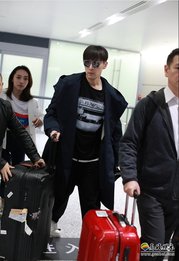 胡歌现身机场担任金马奖颁奖嘉宾后返沪长风衣戴黑超走路带风