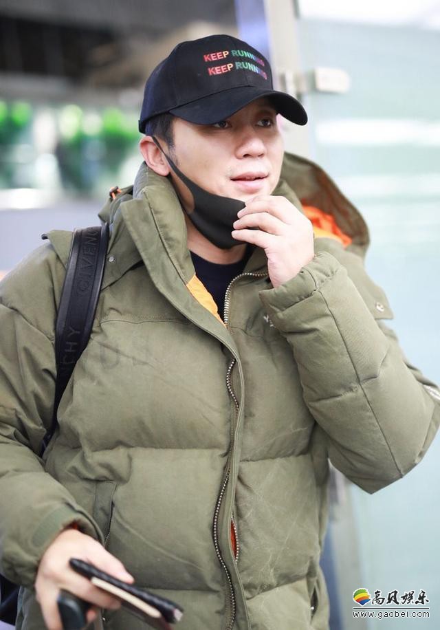 李晨现身机场棒球帽口罩遮面捂严严实实：面对着记者镜头仍不忘打招呼
