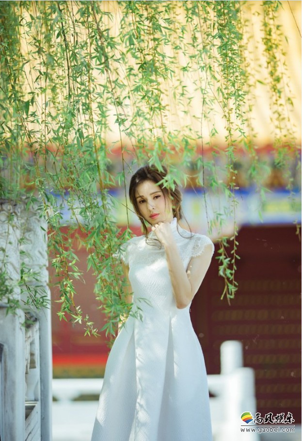 李若彤微博晒出美照：她身穿一袭白裙，漫游宫廷，手拿鲜花，娇媚可人