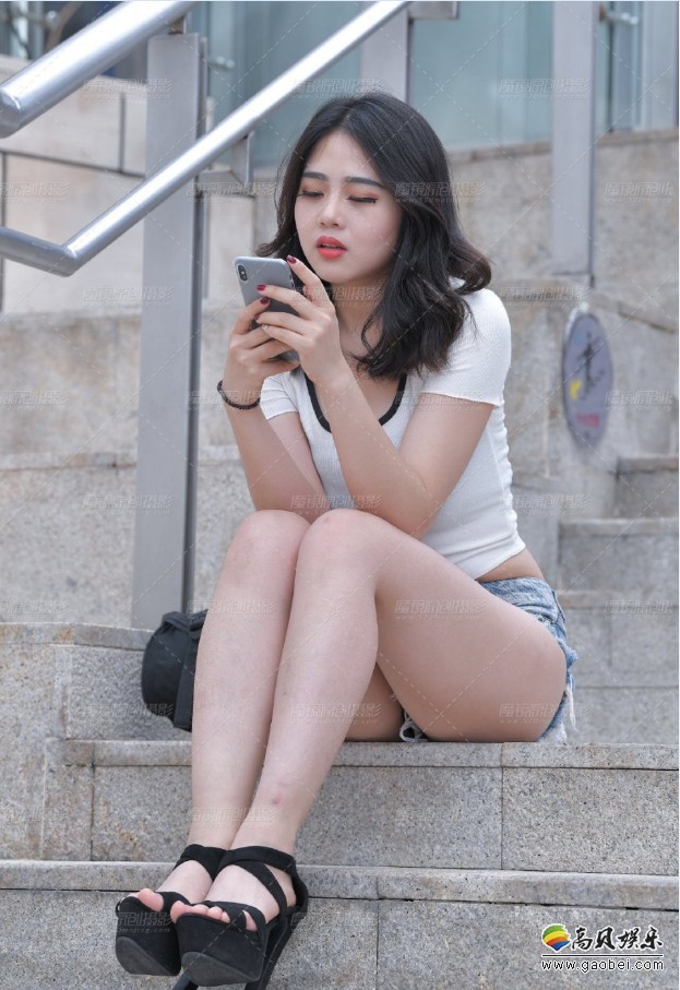 丰满小姐姐热裤搭配露脐T恤：街边独自惬意玩手机，整个街头靓丽风景