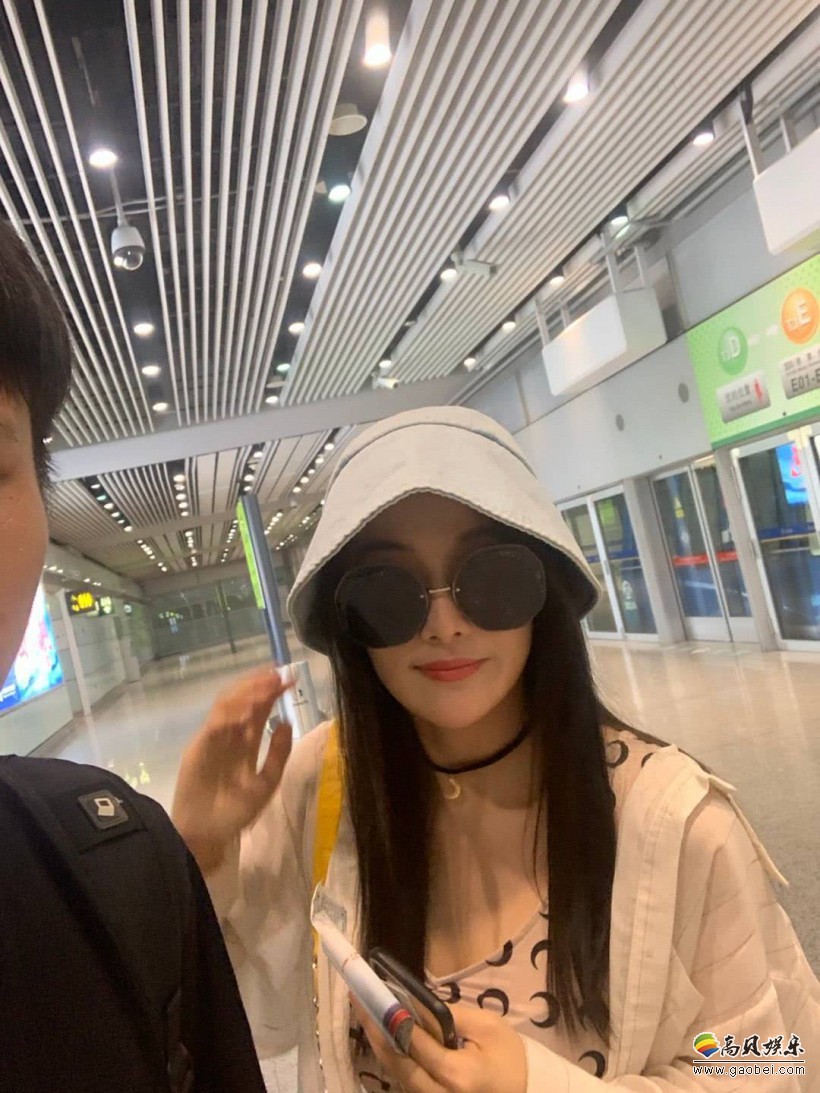 网友北京机场偶遇张馨予：头戴灰帽子和黑墨镜，对着镜头露出灿烂笑容