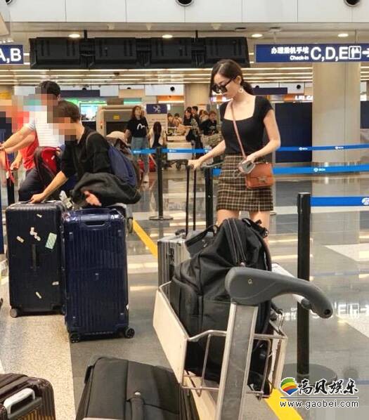 网友北京机场偶遇古力娜扎，身穿格子短裙和黑色修身上衣，装扮十分时尚