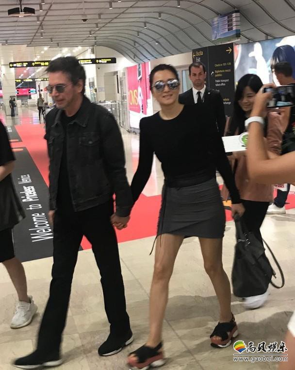 网友晒出威尼斯机场偶遇巩俐夫妇照片，巩俐与老公米歇尔·雅尔甜蜜秀恩爱