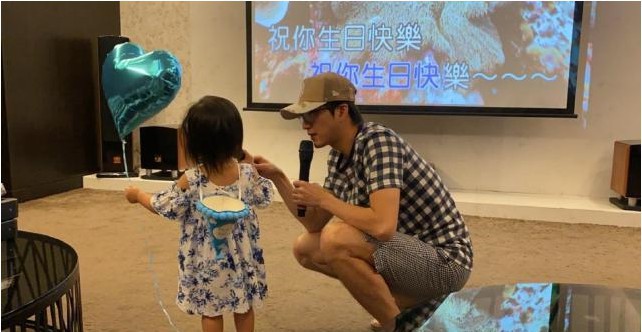 江宏杰晒出女儿爱拉萌照为其庆生，爱拉手拿着话筒，怀抱着气球萌态十足