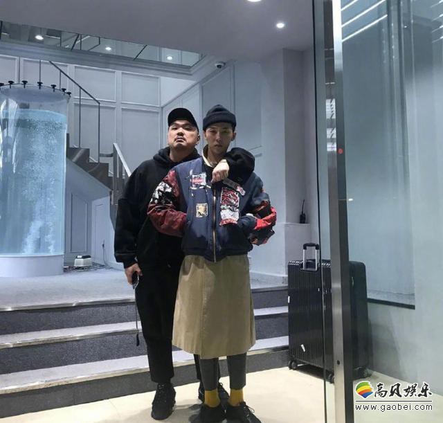 权志龙退伍后近照曝光，蓝色外套长裙，头戴黑色毛线帽，看起来在试衣服