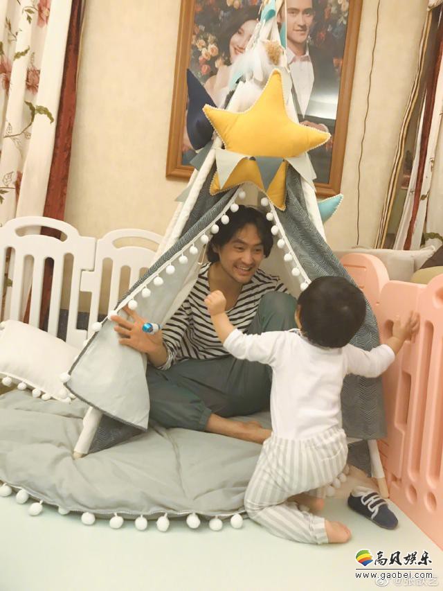 张歆艺微博晒出萌娃近照，袁弘坐在帐篷里，撩开帘子在逗儿子，画面温馨
