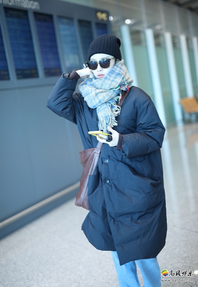 倪妮现身机场，戴针织帽和墨镜！身穿黑色羽绒服，超厚围巾包裹十分严实