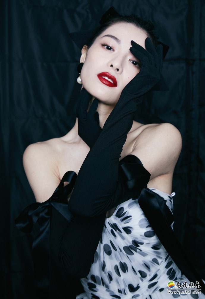 钟楚曦晒出参加活动美照，她身着黑白波点抹胸长裙，搭配标志性红唇妆容