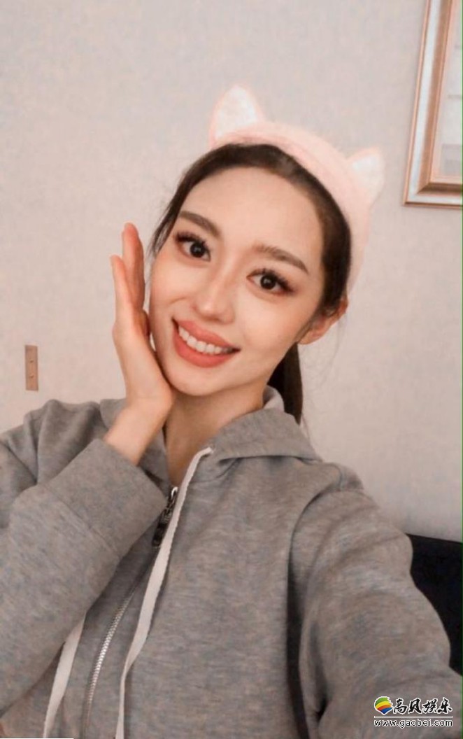 吉娜微博晒出可爱自拍照,一手拿着相机对镜自拍,一手捧着脸,红唇大眼