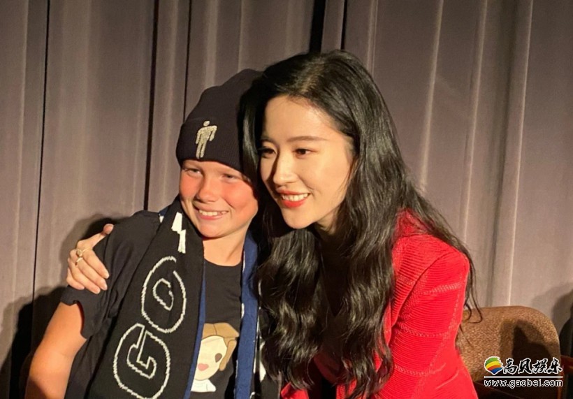 电影《花木兰》北美路演，刘亦菲身穿红色小西装，笑容甜美并与影迷合影